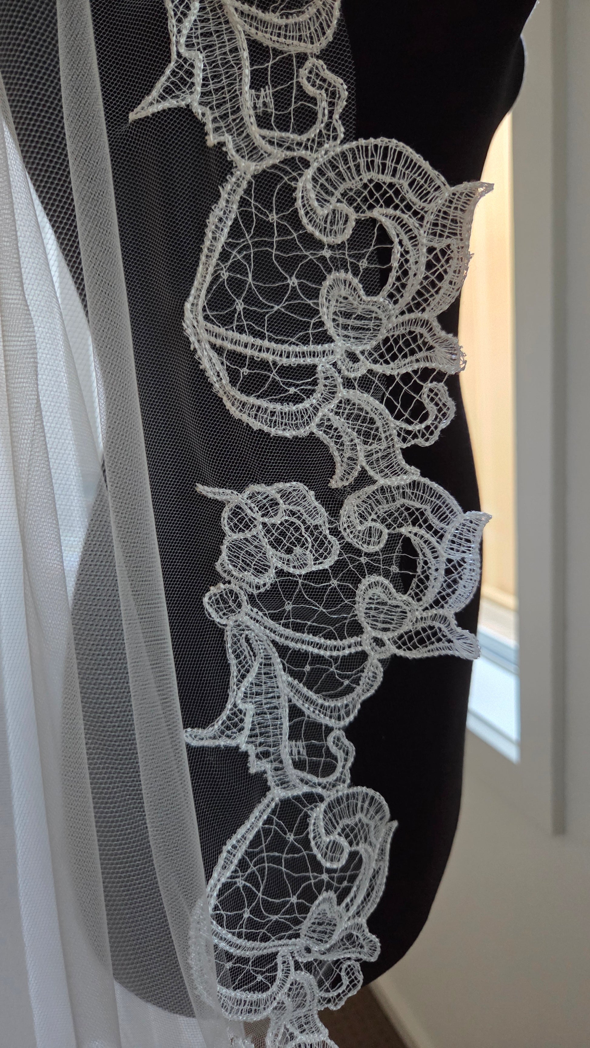 Close-up of an ivory lace detailing, mantilla veil short